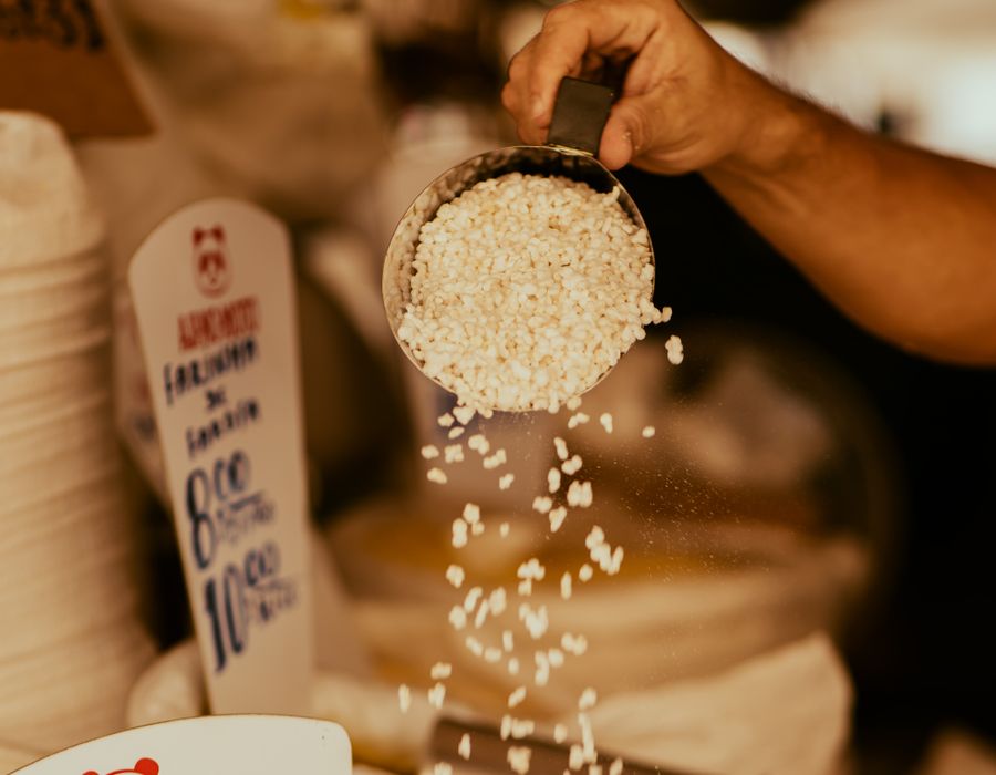 Vendedor derramando farinha de tapioca na feira